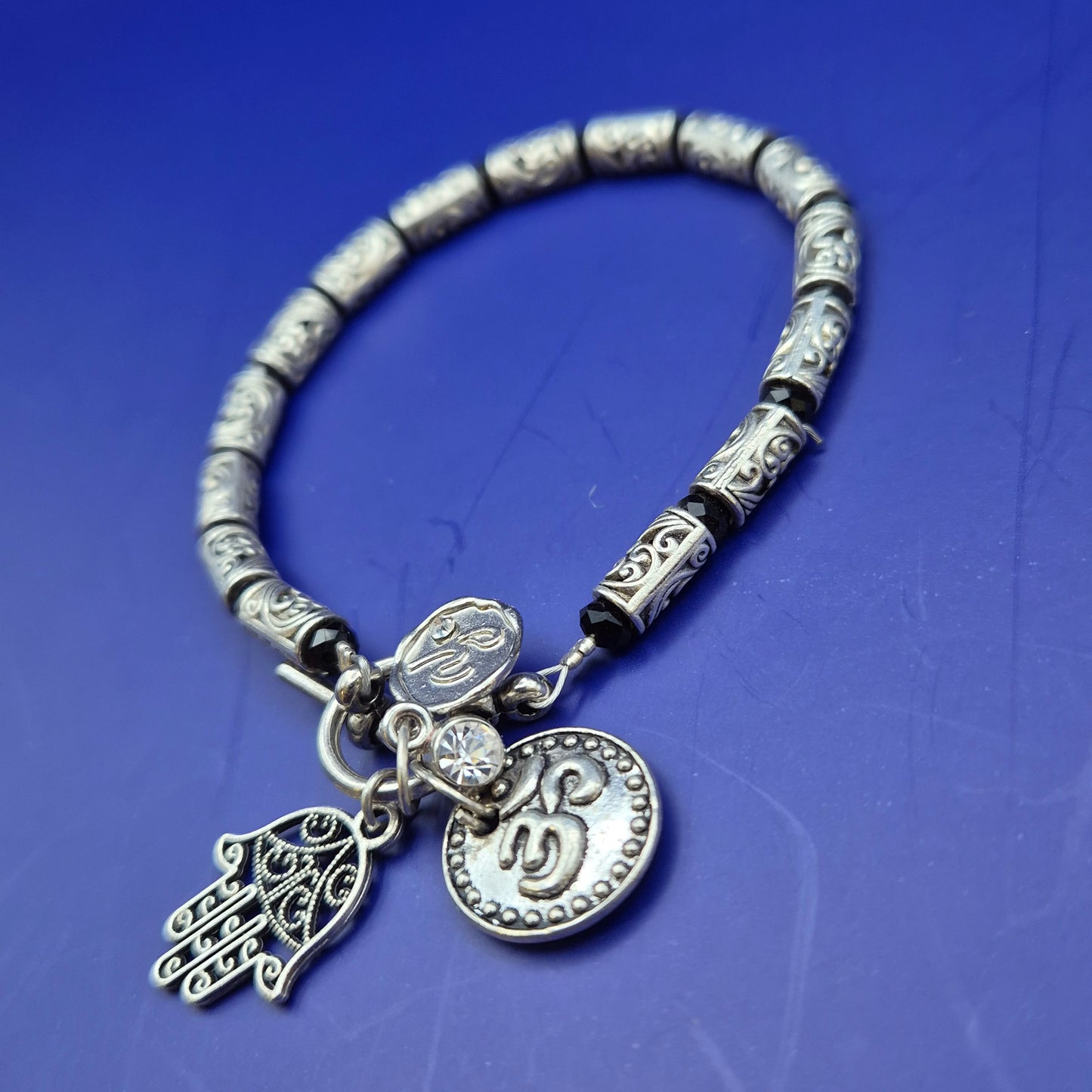 Silberfarbenes Armband mit Hamsa und Om Charm Anhängern