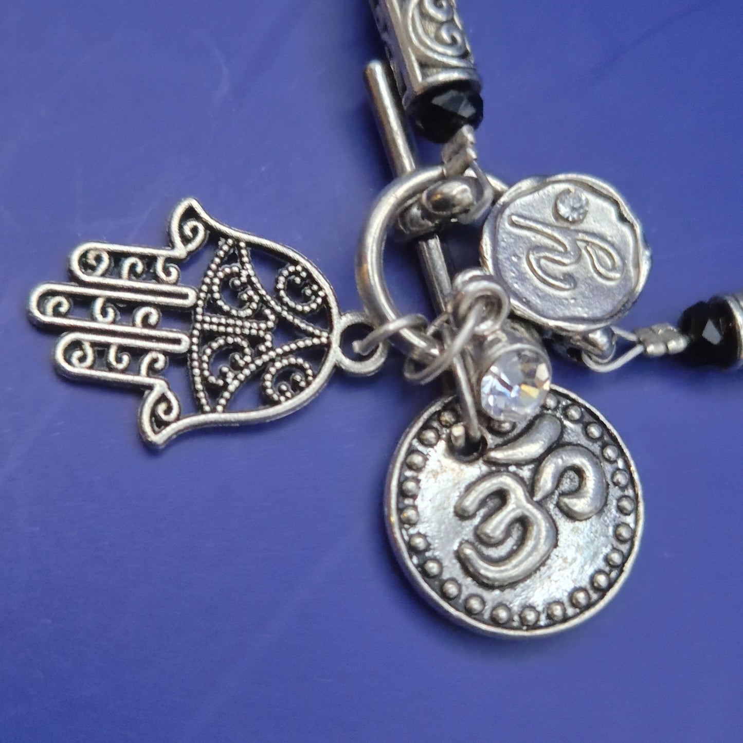 Silberfarbenes Armband mit Hamsa und Om Charm Anhängern