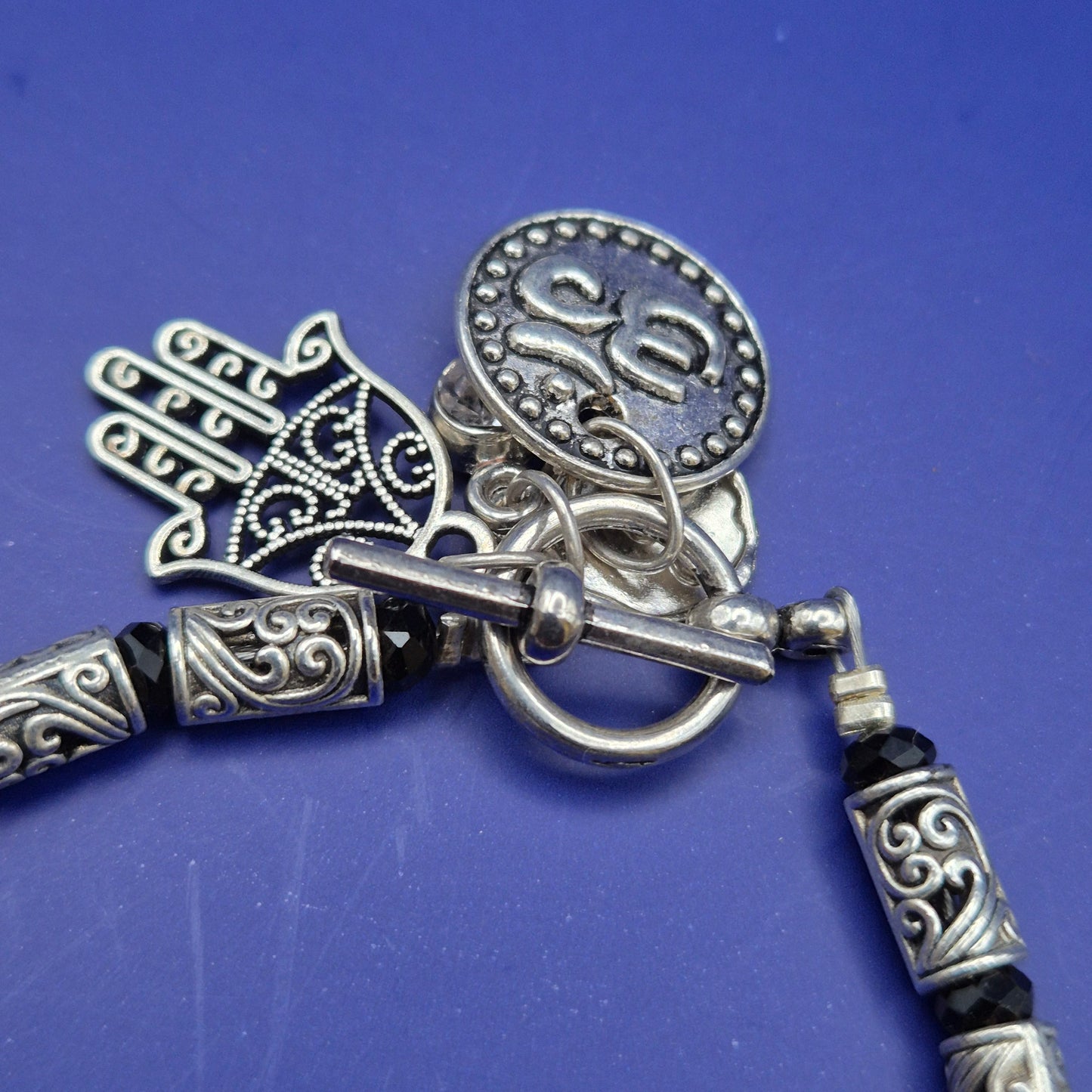 Silberfarbenes Armband mit Hamsa und Om Charm Anhängern
