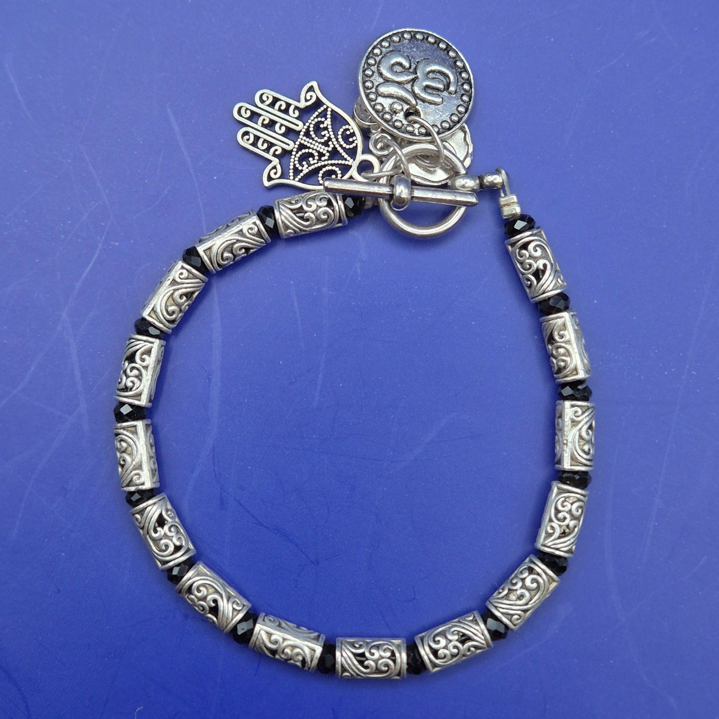 Silberfarbenes Armband mit Hamsa und Om Charm Anhängern