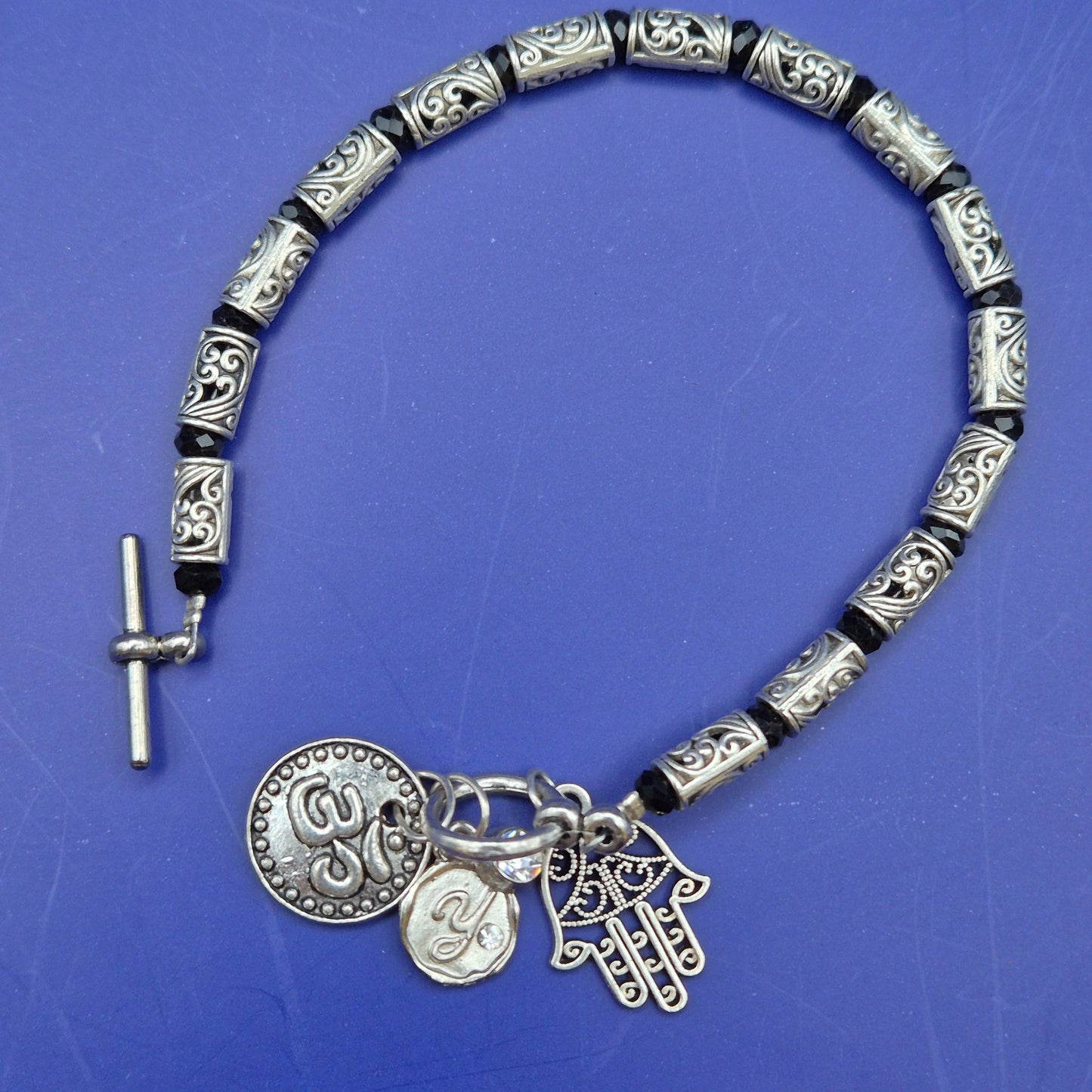 Silberfarbenes Armband mit Hamsa und Om Charm Anhängern