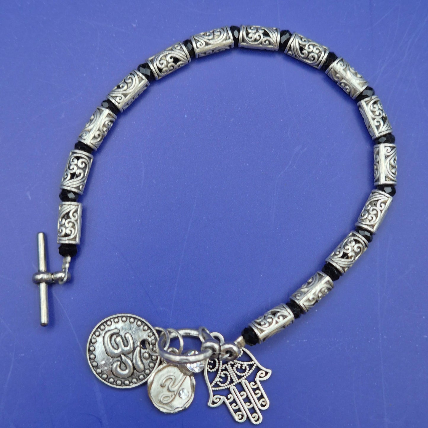 Silberfarbenes Armband mit Hamsa und Om Charm Anhängern