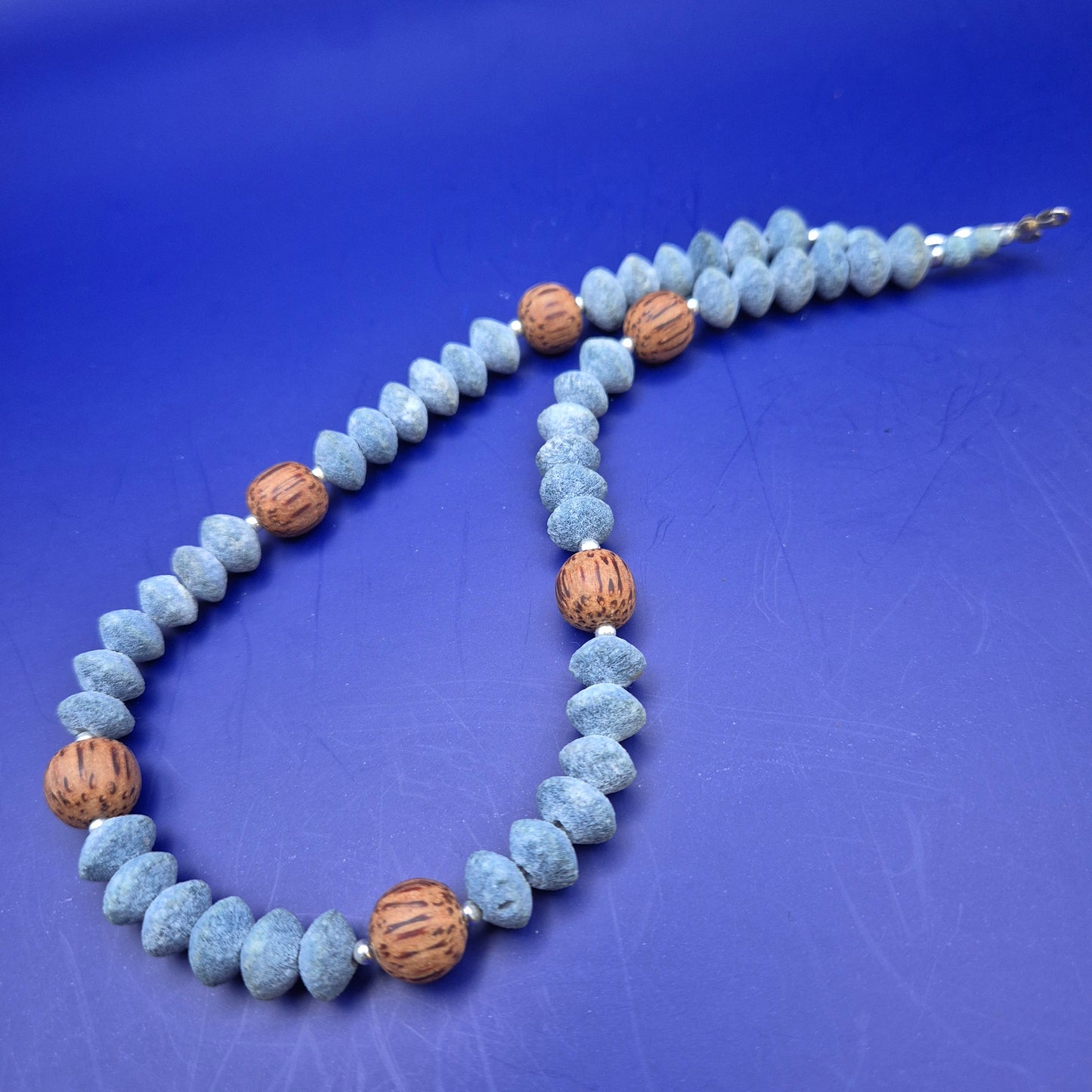 Handgefertigte Kette aus blauen Holzperlen und Kokosnuss-Elementen