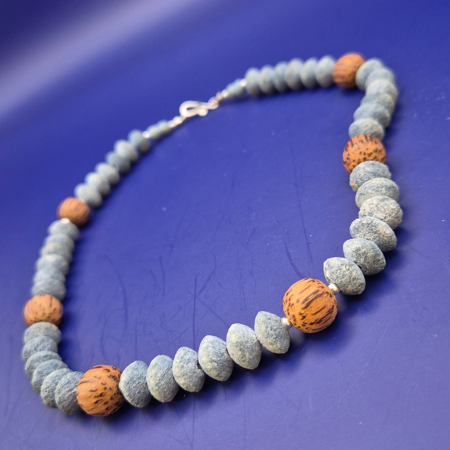 Handgefertigte Kette aus blauen Holzperlen und Kokosnuss-Elementen