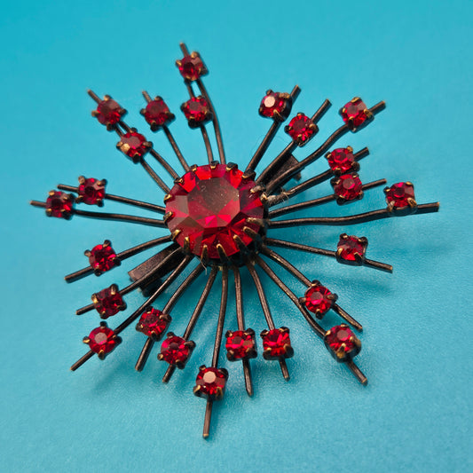 Vintage Starburst Brosche mit roten Strasssteinen in dunklem Metall