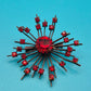 Vintage Starburst Brosche mit roten Strasssteinen in dunklem Metall