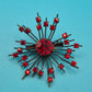 Vintage Starburst Brosche mit roten Strasssteinen in dunklem Metall