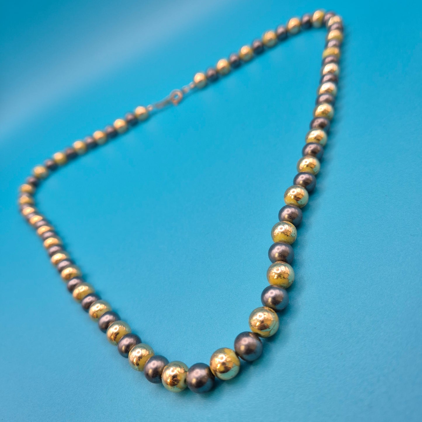 Elegante Vintage-Kette mit grauen Perlen und goldenen Elementen