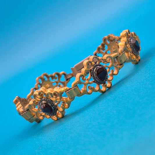 Antikes Gliederarmband mit Granatsteinen in goldfarbenem Filigran-Design