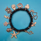 Verspieltes Vintage Charm-Armband mit schwarzen Perlen und Anhängern