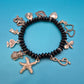 Verspieltes Vintage Charm-Armband mit schwarzen Perlen und Anhängern