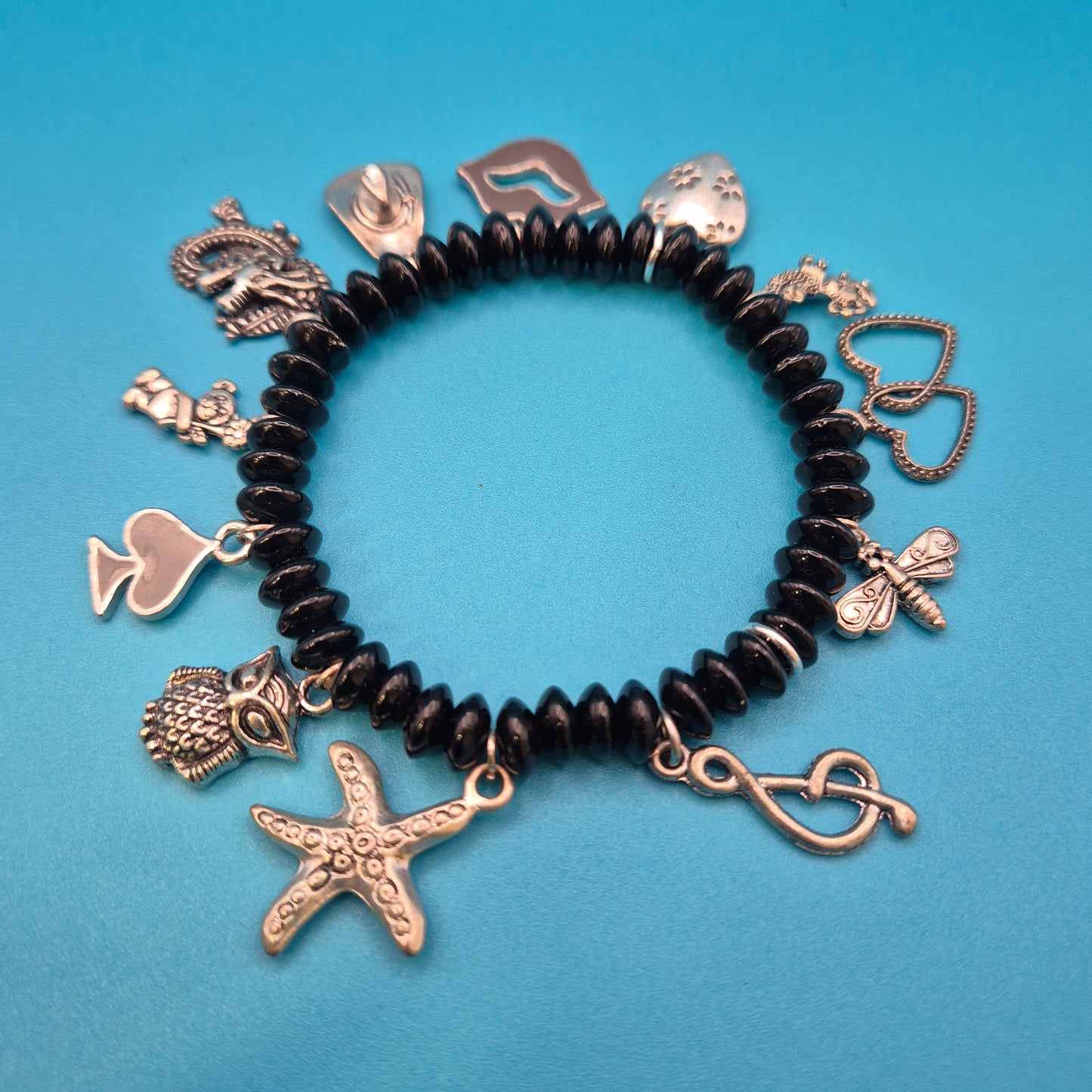 Verspieltes Vintage Charm-Armband mit schwarzen Perlen und Anhängern