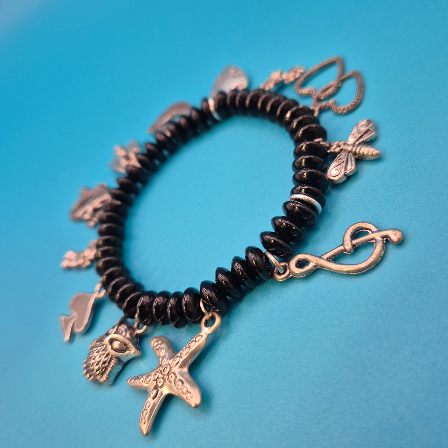 Verspieltes Vintage Charm-Armband mit schwarzen Perlen und Anhängern