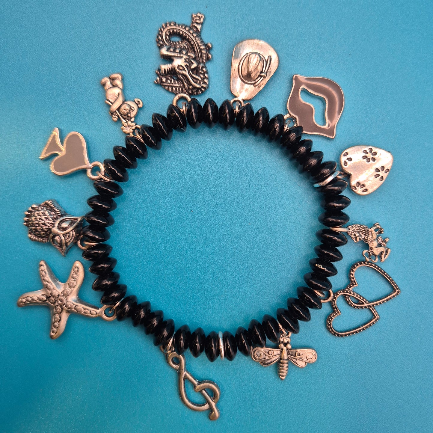 Verspieltes Vintage Charm-Armband mit schwarzen Perlen und Anhängern