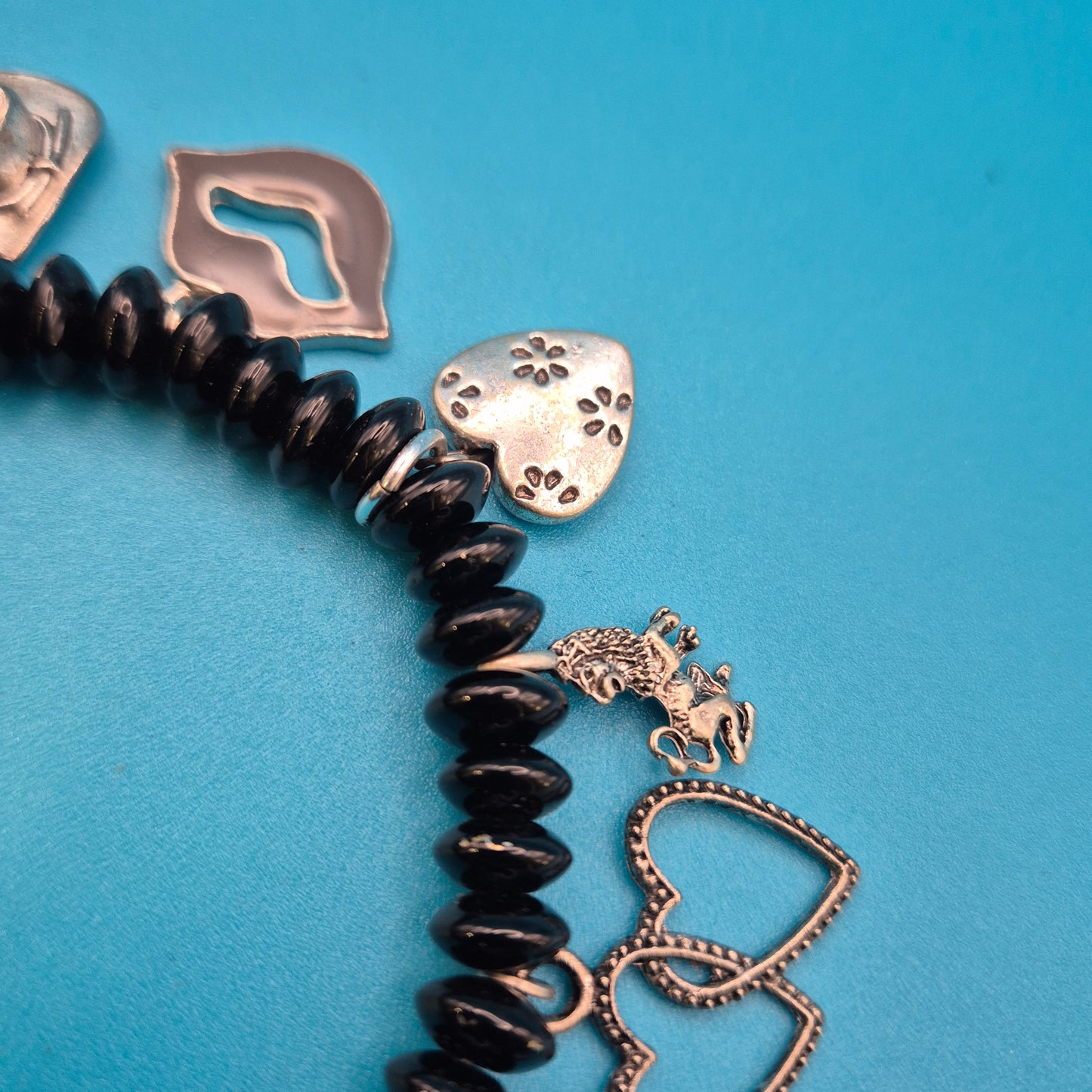 Verspieltes Vintage Charm-Armband mit schwarzen Perlen und Anhängern