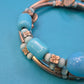 Vintage Wickelarmband in Hellblau mit Charm-Details und goldenen Elementen