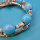 Vintage Wickelarmband in Hellblau mit Charm-Details und goldenen Elementen