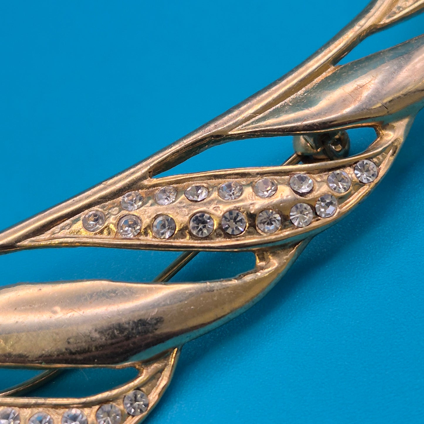Vintage Brosche in Goldoptik mit geschwungenen Akzenten und Strasssteinen