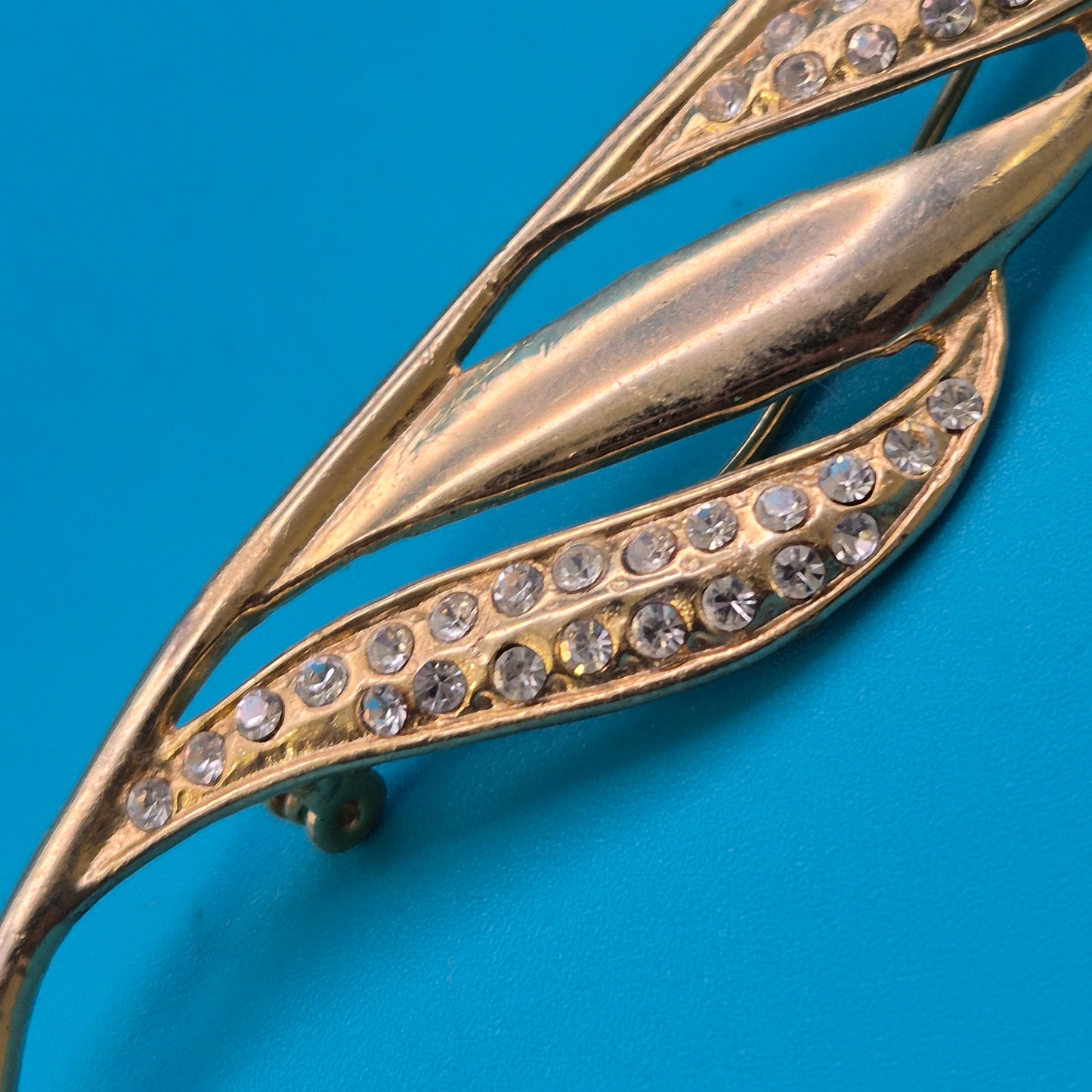 Vintage Brosche in Goldoptik mit geschwungenen Akzenten und Strasssteinen