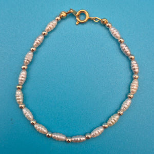 Elegantes Vintage-Armband mit weißen Reisperlen und goldenen Elementen