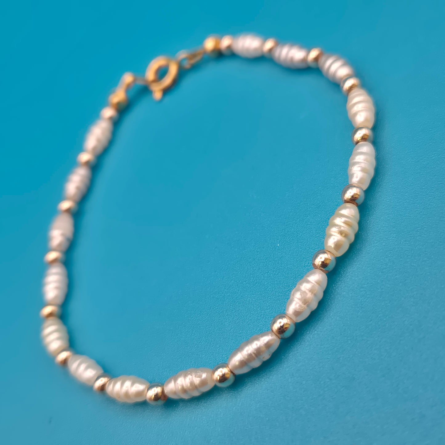 Elegantes Vintage-Armband mit weißen Reisperlen und goldenen Elementen