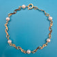 Elegantes Vintage-Armband mit Ziergliedern und weißen Perlen Goldfarben