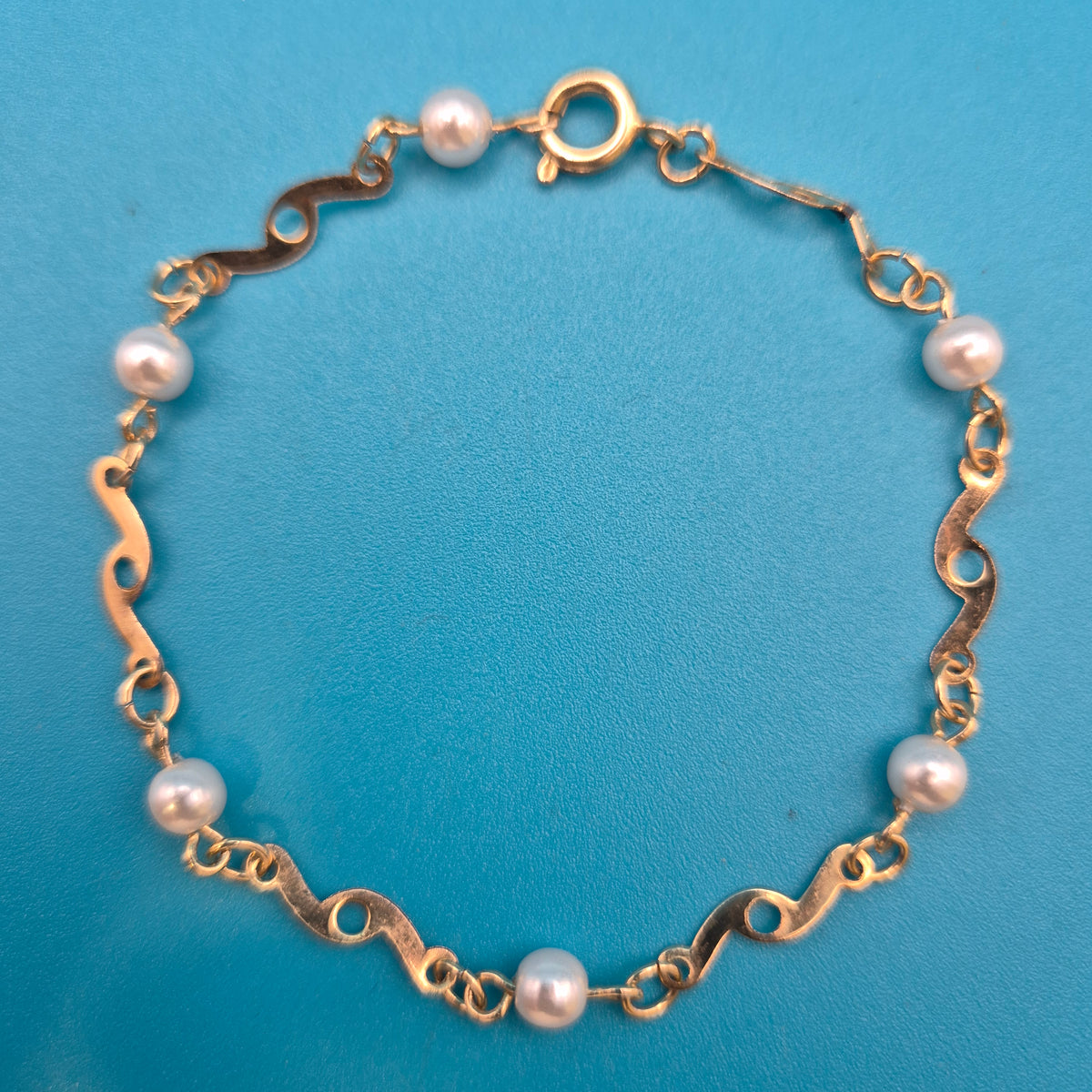 Elegantes Vintage-Armband mit Ziergliedern und weißen Perlen Goldfarben