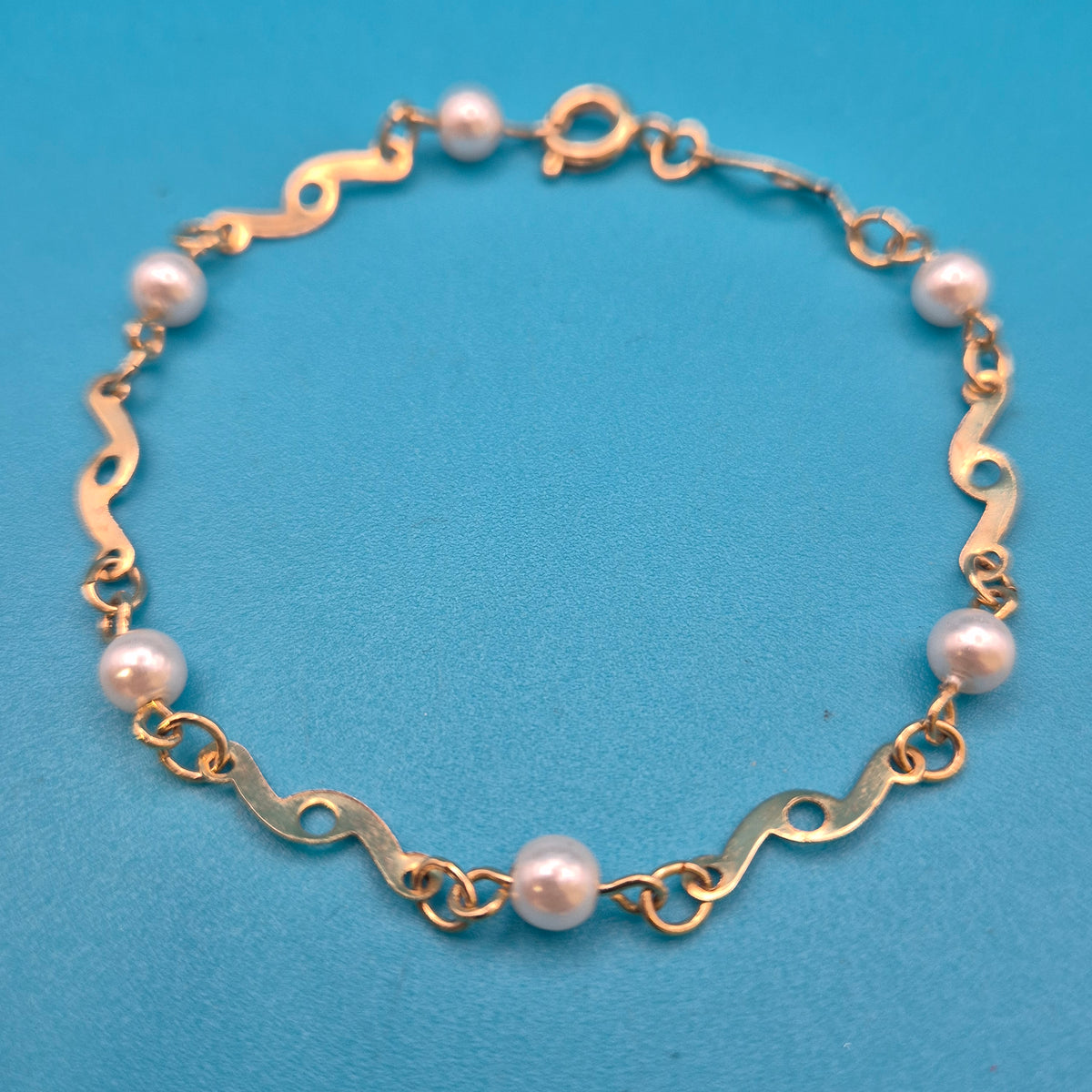 Elegantes Vintage-Armband mit Ziergliedern und weißen Perlen Goldfarben