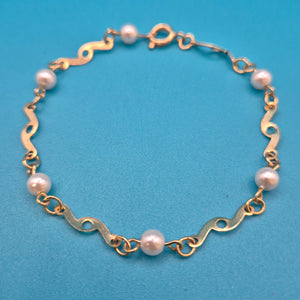 Elegantes Vintage-Armband mit Ziergliedern und weißen Perlen Goldfarben