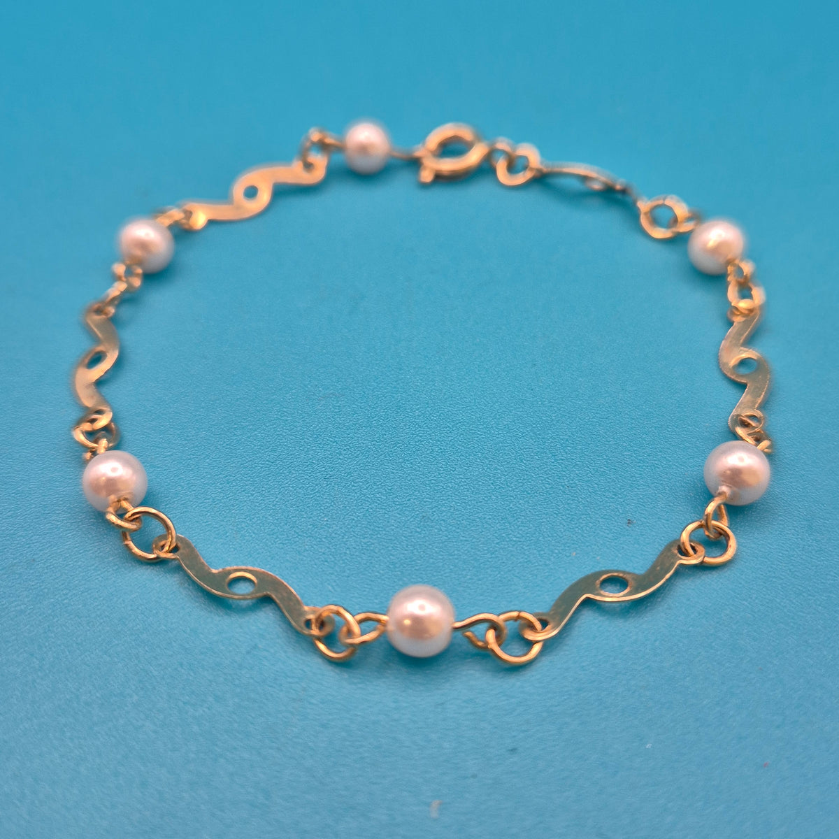 Elegantes Vintage-Armband mit Ziergliedern und weißen Perlen Goldfarben
