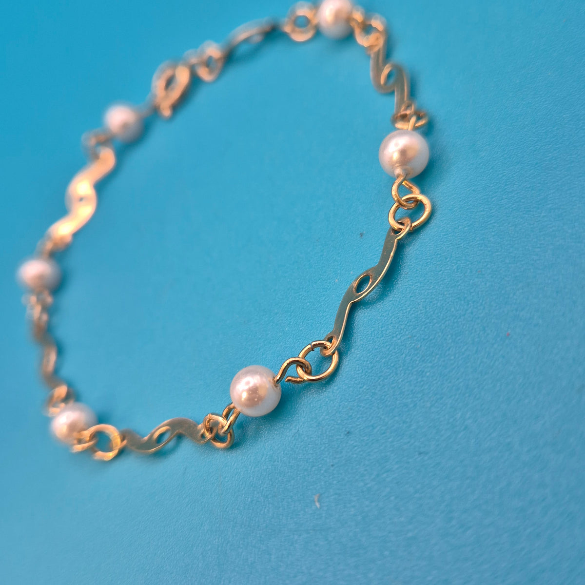 Elegantes Vintage-Armband mit Ziergliedern und weißen Perlen Goldfarben