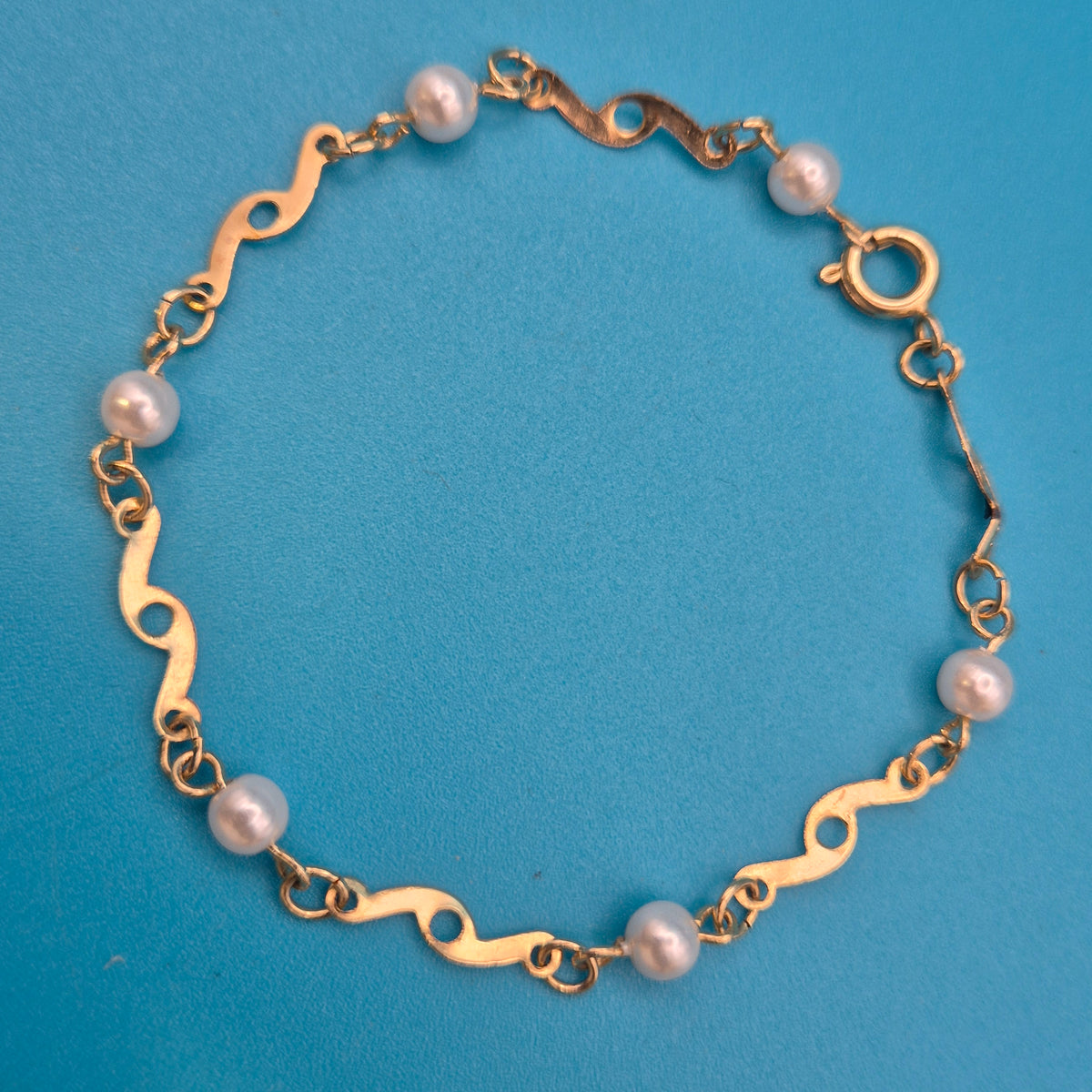 Elegantes Vintage-Armband mit Ziergliedern und weißen Perlen Goldfarben