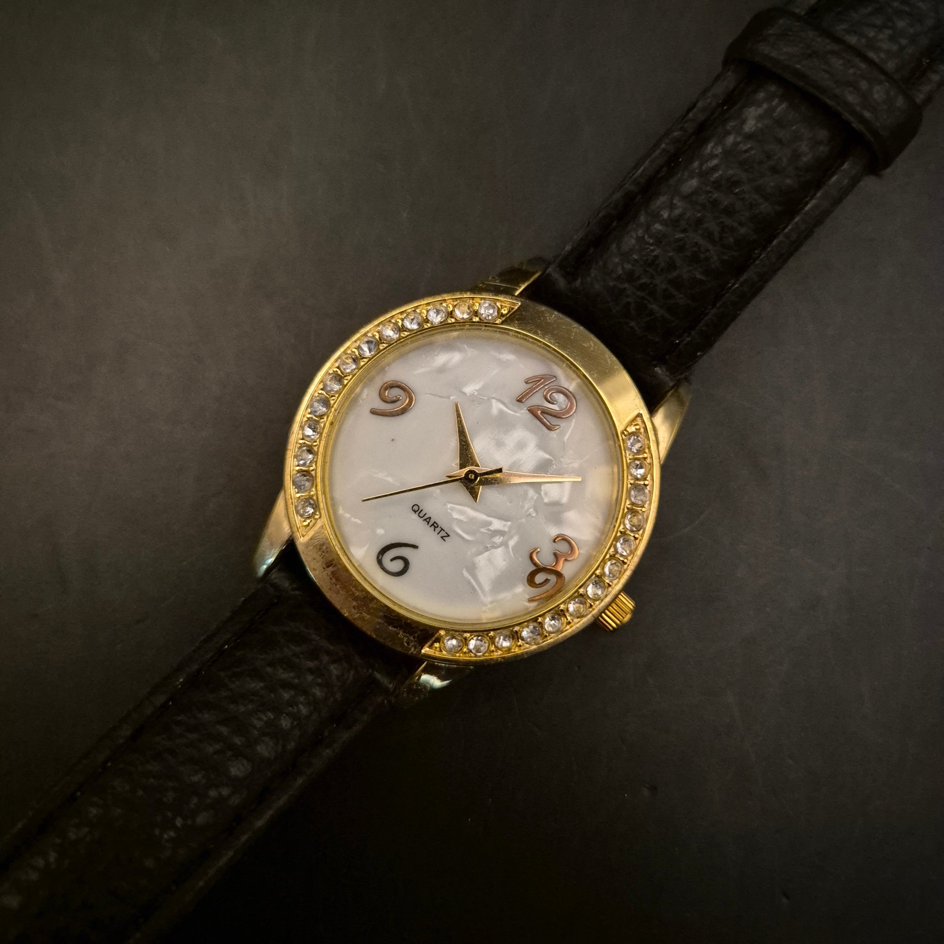 Elegante goldfarbene Damenuhr mit Strass und Perlmutt-Zifferblatt