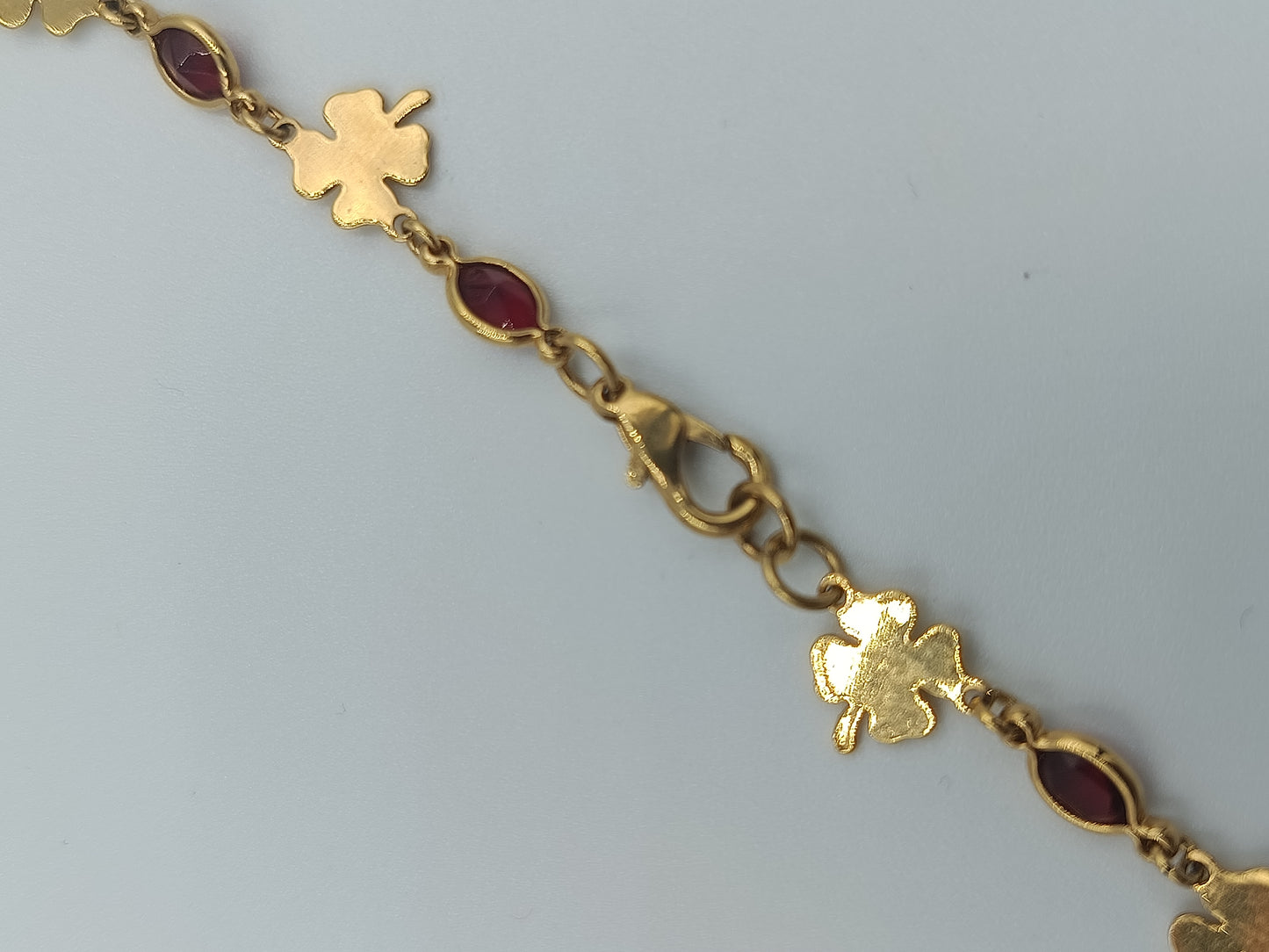 Zarte Goldfarbene Kette mit Kleeblatt- und Rubinroten Elementen