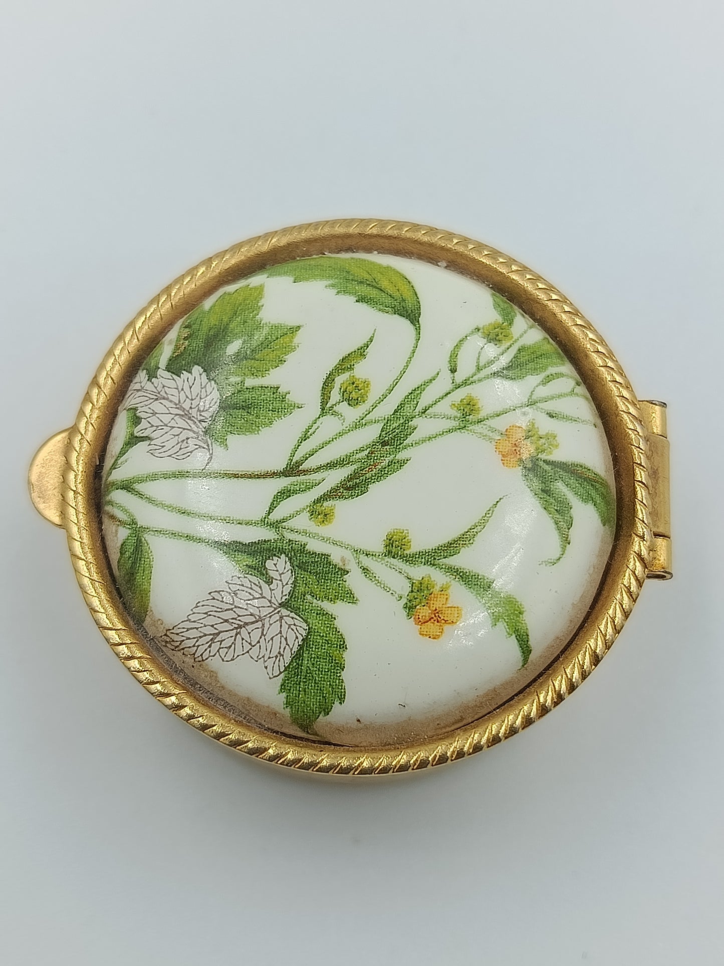 Runde Vintage-Porzellandose mit zarten grünen Blättern