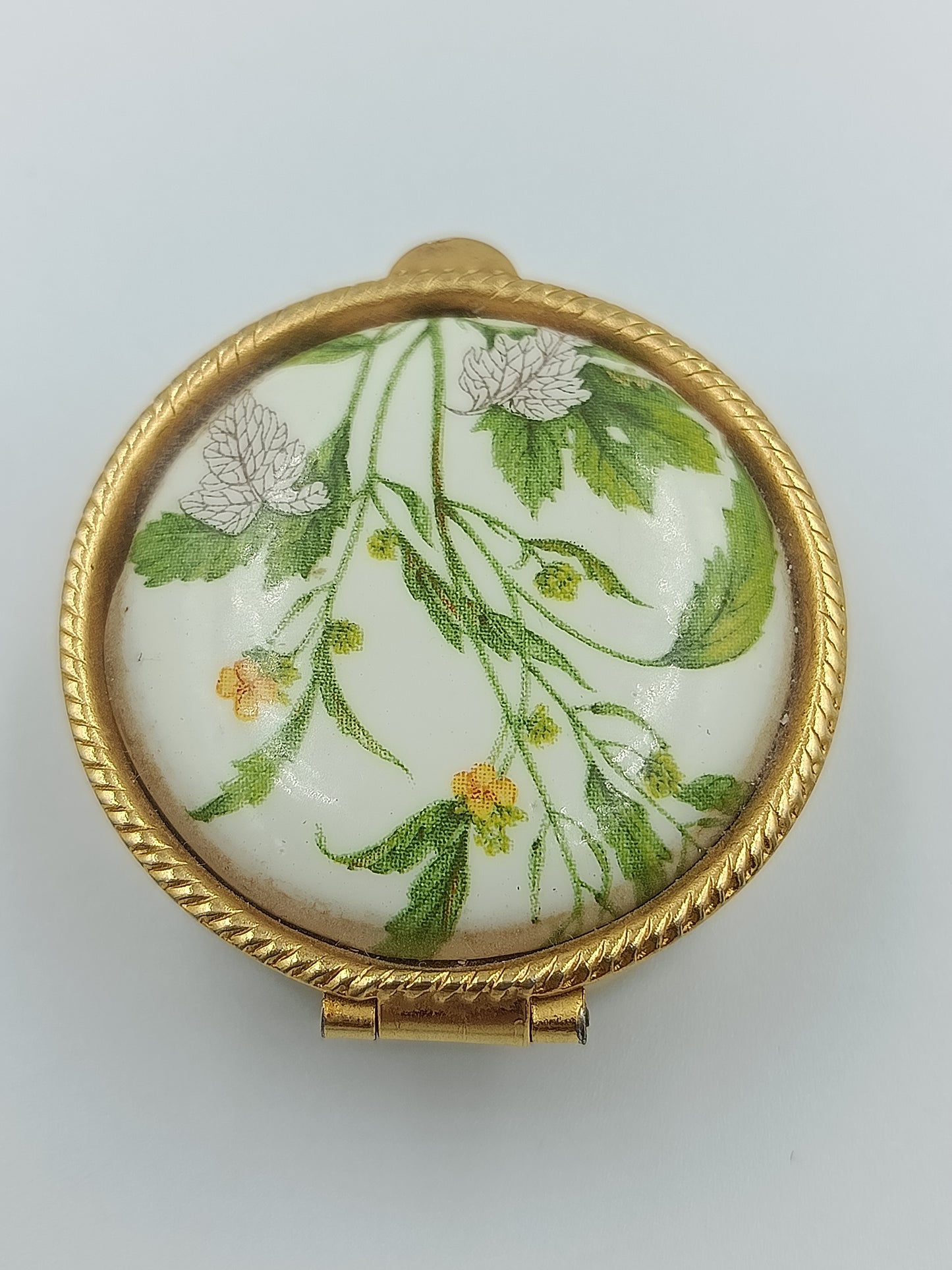 Runde Vintage-Porzellandose mit zarten grünen Blättern