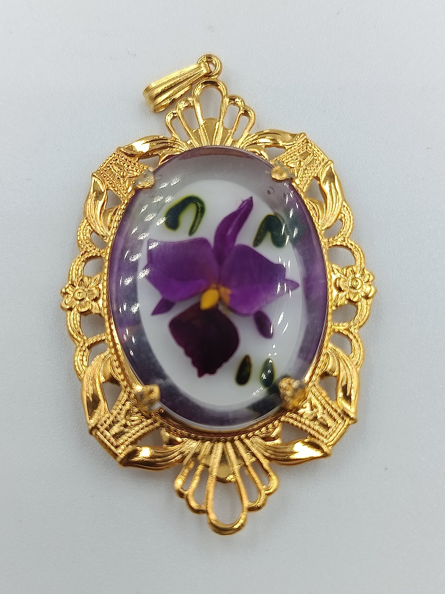 Goldfarbener Anhänger mit handbemaltem Blumenmotiv