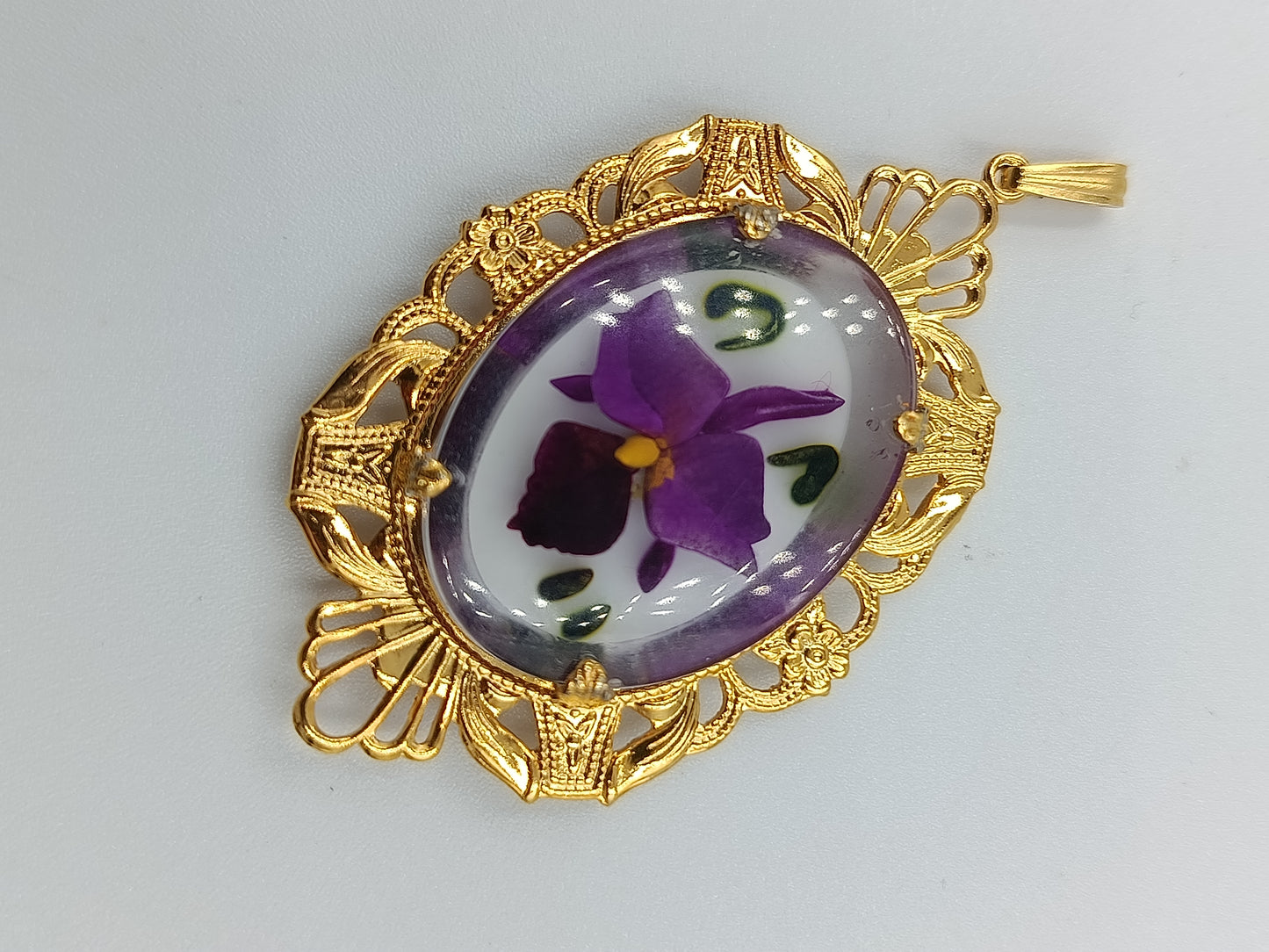 Goldfarbener Anhänger mit handbemaltem Blumenmotiv