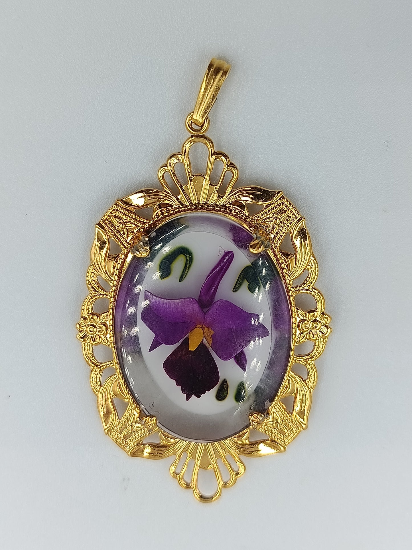 Goldfarbener Anhänger mit handbemaltem Blumenmotiv