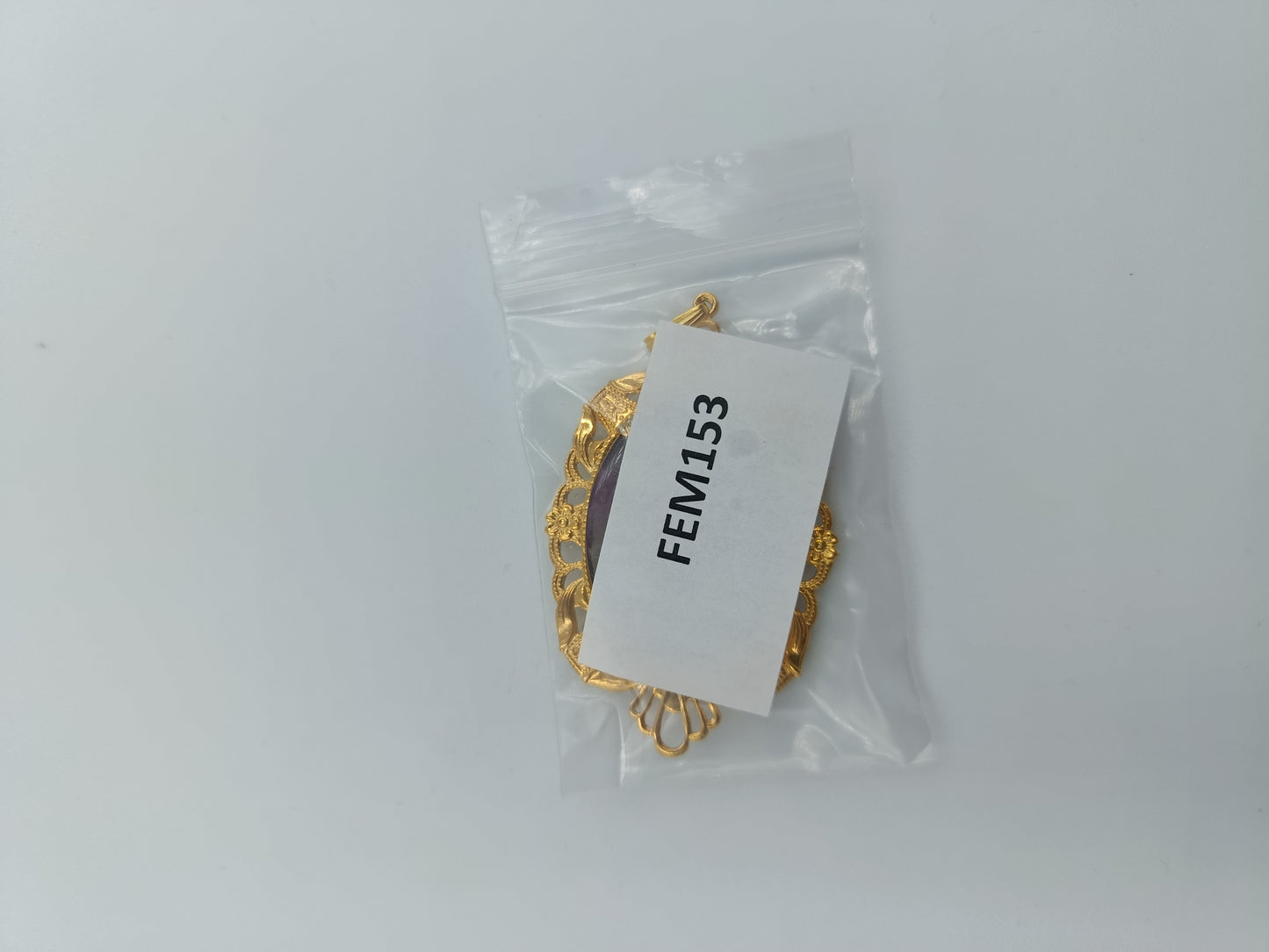 Goldfarbener Anhänger mit handbemaltem Blumenmotiv