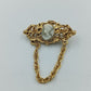 Goldfarbene Kamee-Brosche mit Kette