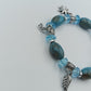 Elastisches Armband mit blauen Perlen und Charms