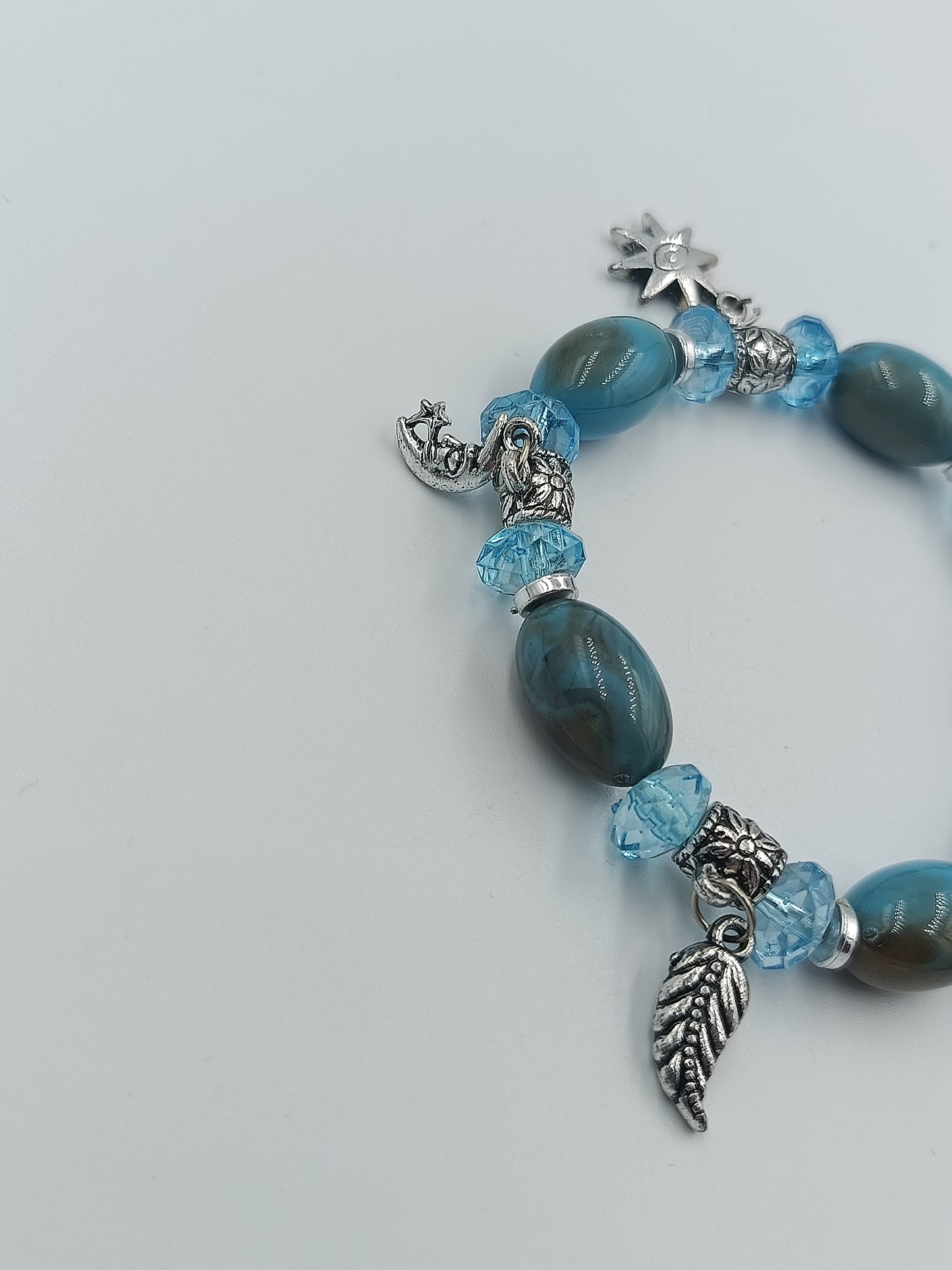 Elastisches Armband mit blauen Perlen und Charms