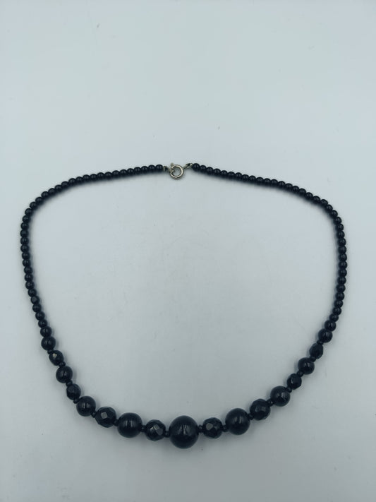 Klassische schwarze Perlenkette mit Facettendetails