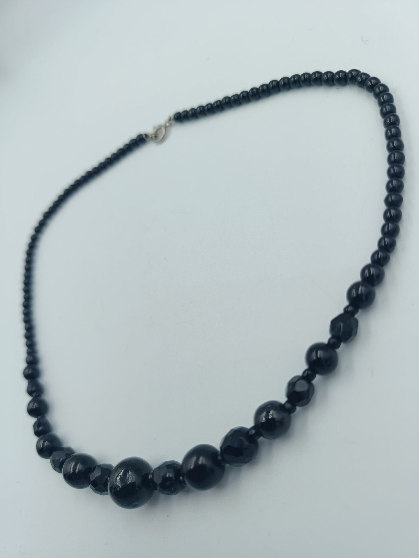 Klassische schwarze Perlenkette mit Facettendetails