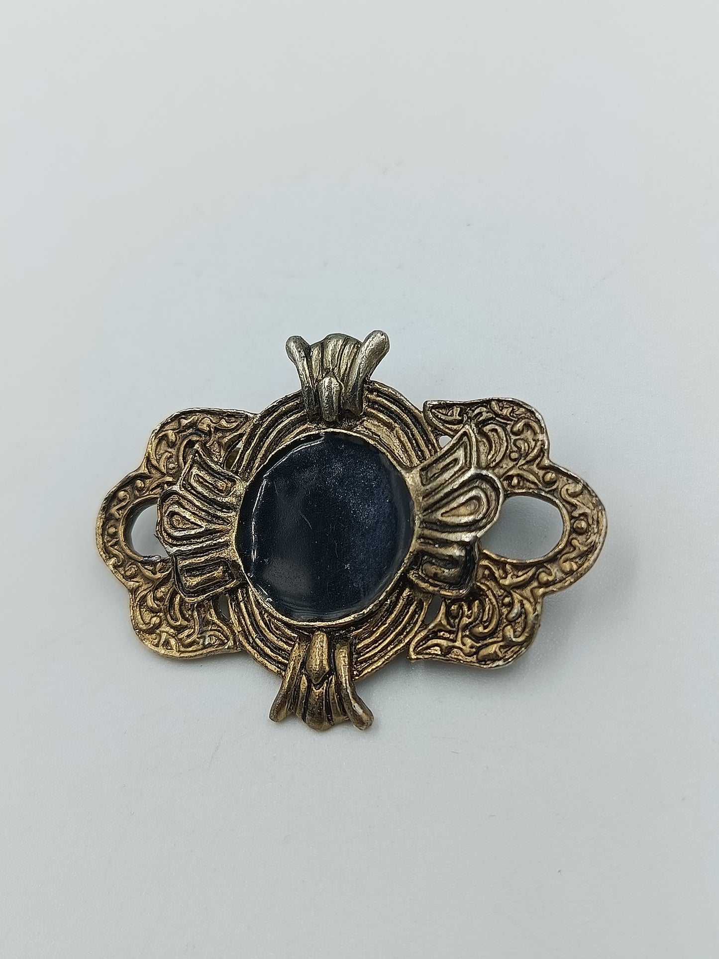 Antik anmutende Brosche mit dunkelblauem Stein