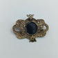 Antik anmutende Brosche mit dunkelblauem Stein