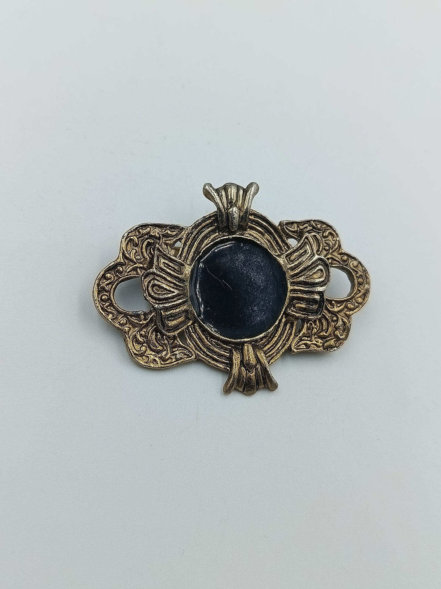 Antik anmutende Brosche mit dunkelblauem Stein