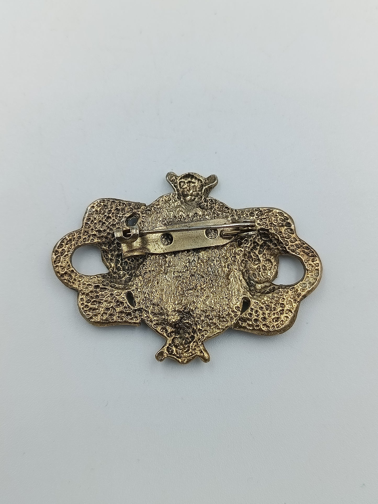 Antik anmutende Brosche mit dunkelblauem Stein