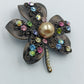 Brosche mit bunten Strasssteinen und Perle